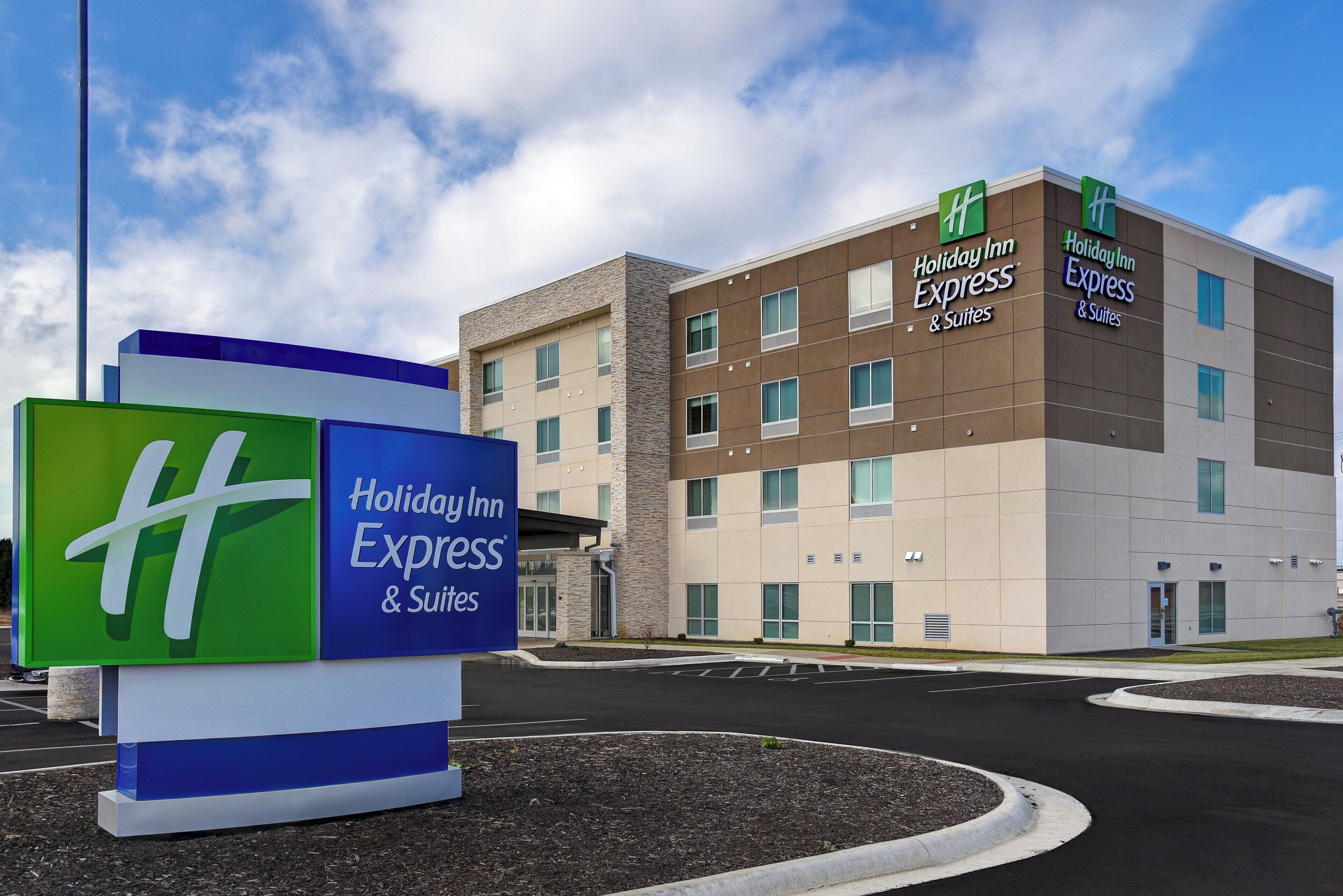 A Holiday Inn Express & Suites building with a signboard in front.