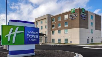 A Holiday Inn Express & Suites building with a signboard in front.