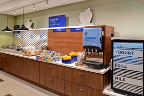 A breakfast area with a Squeeze the Day dispenser, a refrigerator with yogurt, eggs, and milk, and a sign for Express Start Breakfast. - Holiday Inn Express & Suites Ottawa by IHG (Ottawa)