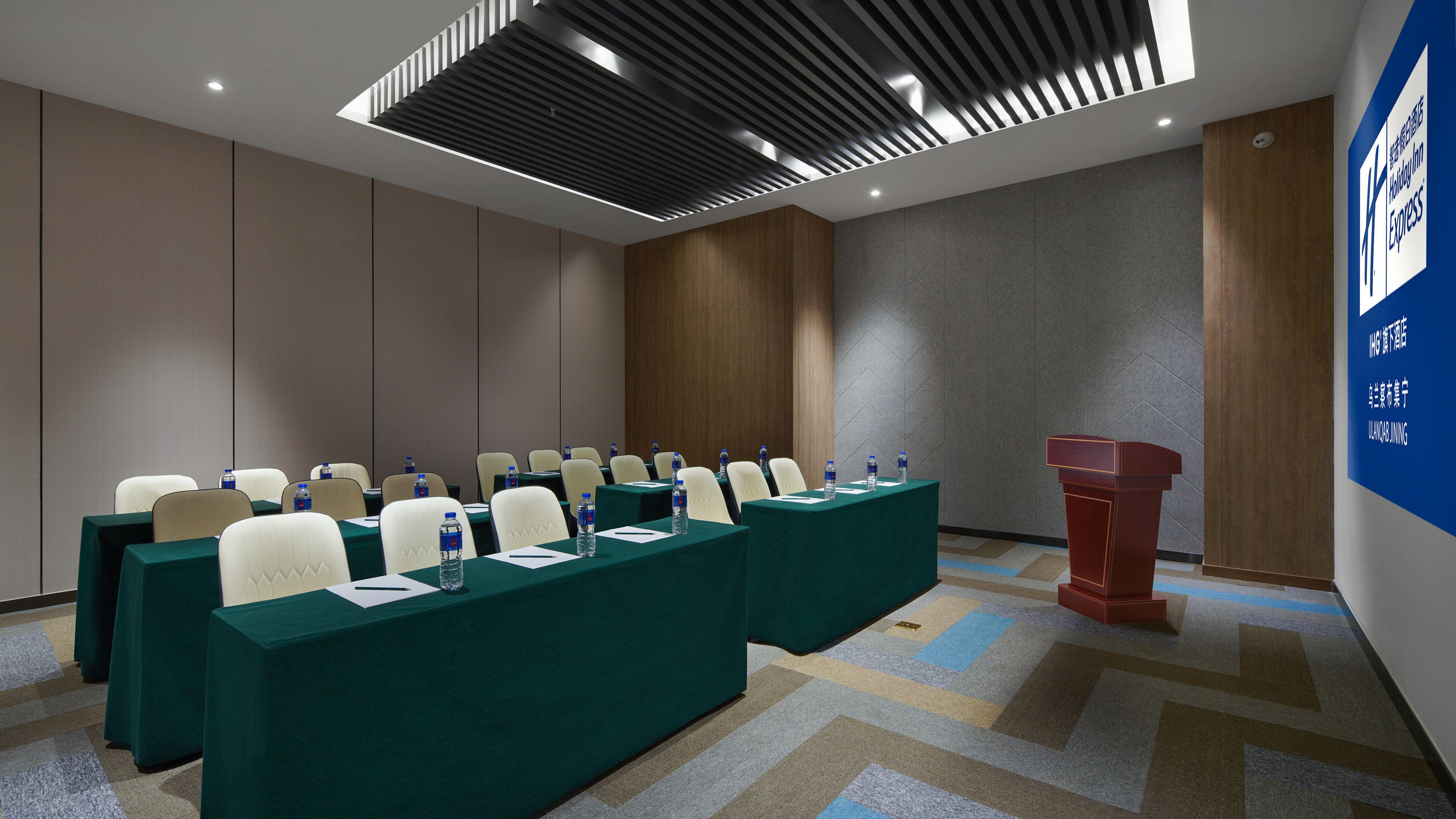 Una sala conferenze con un lungo tavolo, sedie e un podio.