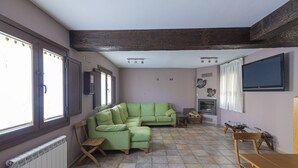 Ein Wohnzimmer mit einem Ecksofa, einer Holzbank und einem Kamin.