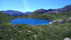 A lake surrounded by mountains with a clear sky. - Tivoli (Andorra la Vella)