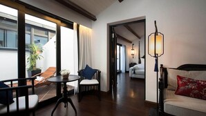 Una habitación de hotel moderna con balcón, comedor y sala de estar.
