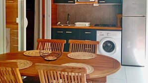Une cuisine compacte équipée d’un lave-linge, d’un four à micro-ondes et de placards.