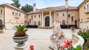 Un bâtiment imposant doté d’une cour intérieure, d’une statue de lion et d’un jardin bien entretenu.