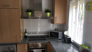 Een keuken met een Bosch oven, een magnetron, een broodrooster en een wasmachine.