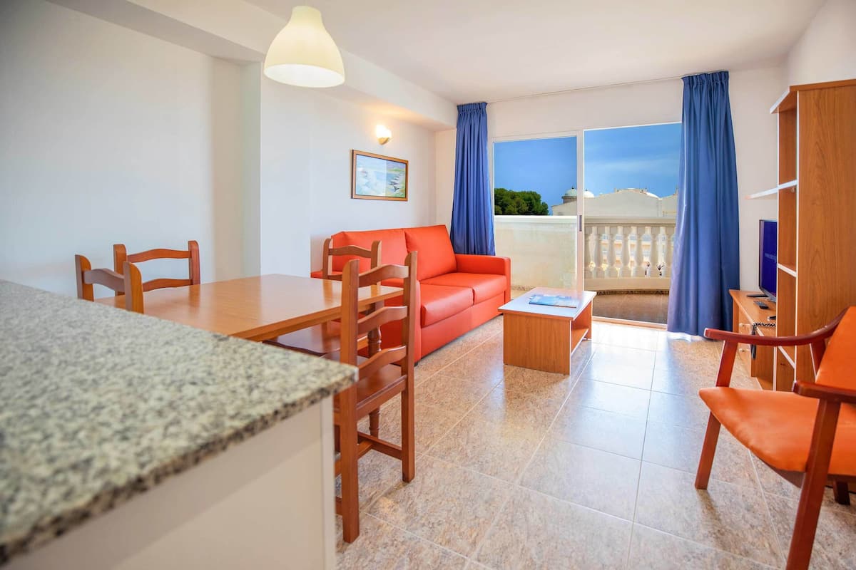 Un salon moderne comprenant un coin repas, un canapé, une table basse et un balcon avec vue.