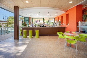 A modern bar area with a counter, bar stools, and a seating area with chairs. - Hotel Servigroup Romana (Alcala de Xivert)