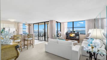 Apartamento, varias camas, piscina privada, vistas a la playa | Zona de estar | Una televisión