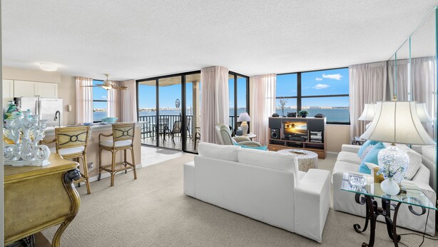 A modern hotel room with a living area, dining space, and a balcony with a view. - Casa Del Mar G-608 by Distinctive Beach Rentals (St. Petersburg)