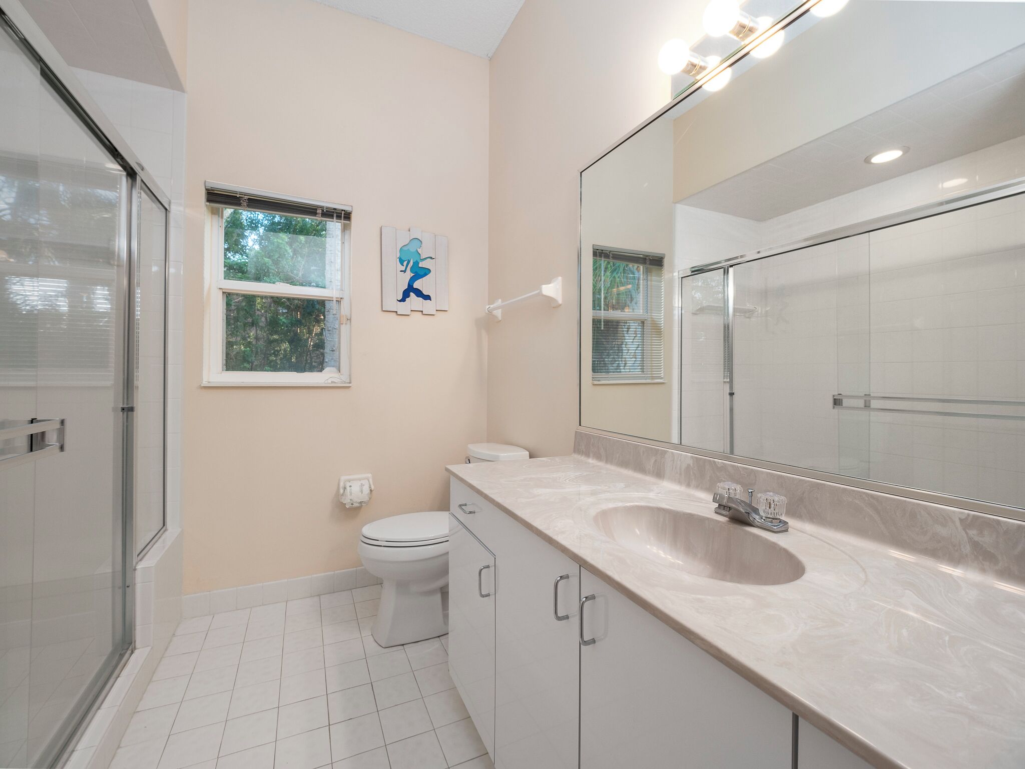 Un baño moderno con inodoro, lavamanos y ducha.