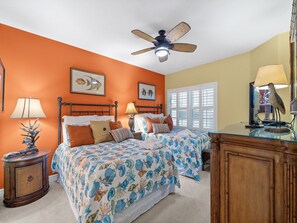 A bedroom with two beds, a ceiling fan, and a window with blinds. - La Vistana 703 by Distinctive Beach Rentals (Redington Shores)