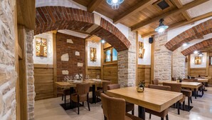 A restaurant with brick arches, wooden beams, stone walls, and a clean, modern interior.