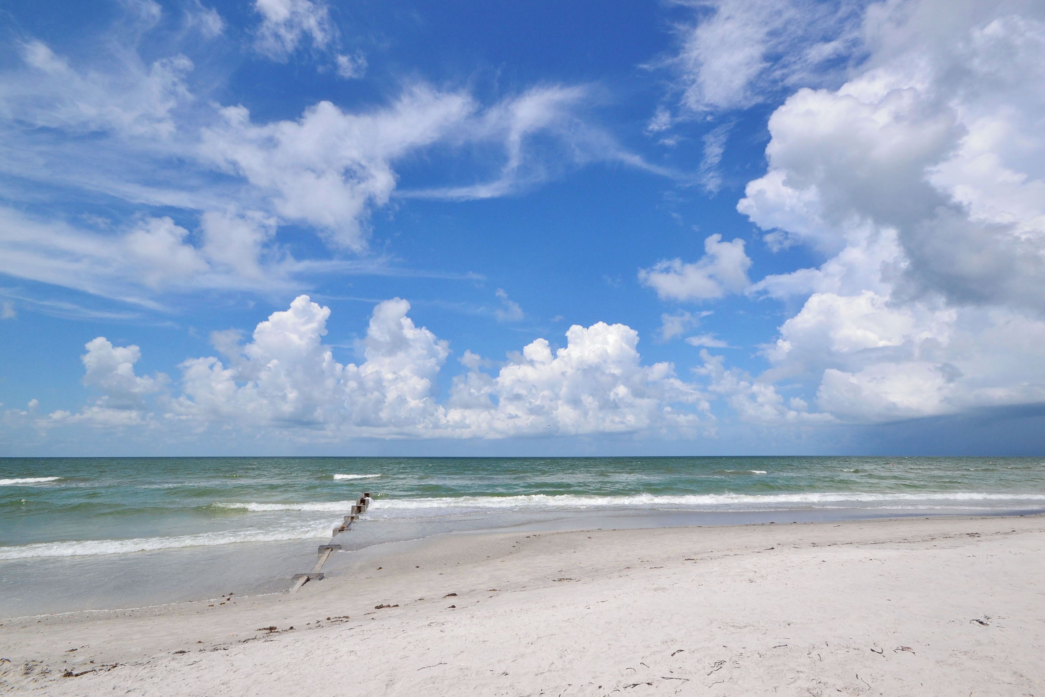 A beach with a clear sky and ocean waves.