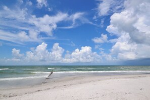 A beach with a clear sky and ocean waves.