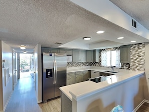 A modern kitchen with a stainless steel refrigerator, a microwave, and a dishwasher.