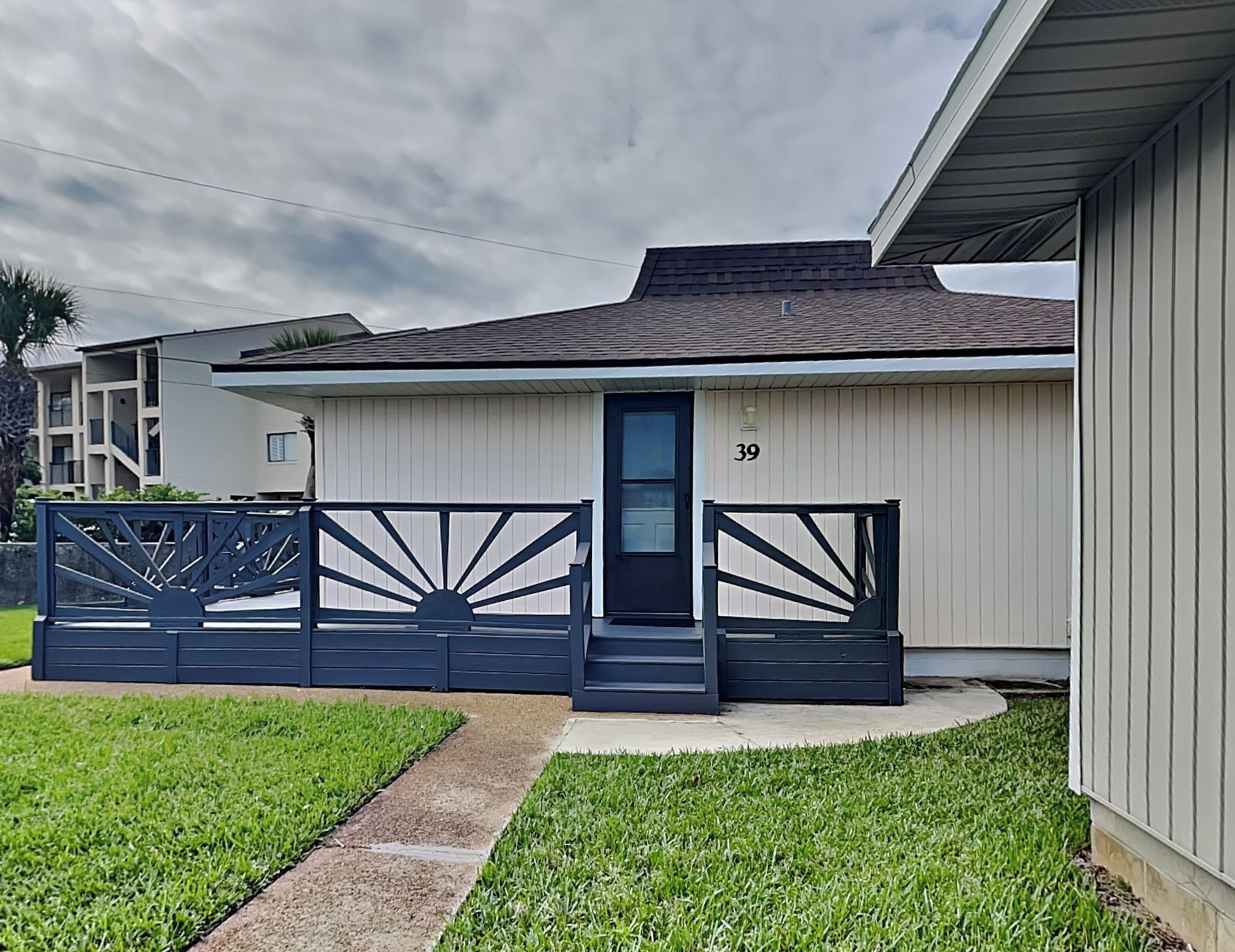 A single-story house with a dark blue gate and a number 39 on the door.
