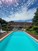 Una piscina al aire libre de temporada, sillones reclinables de piscina