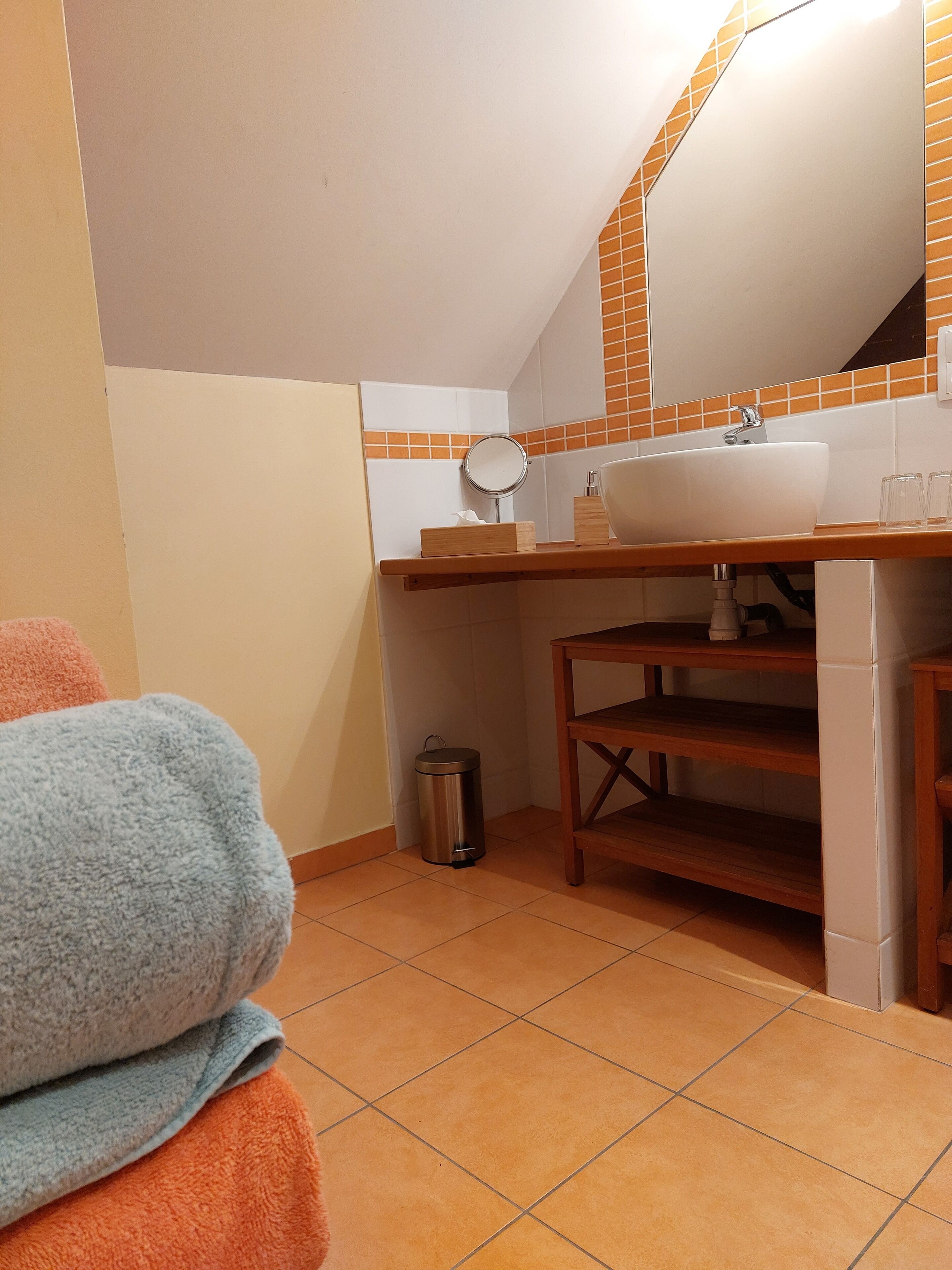 Un bagno con lavandino, specchio e pavimento piastrellato.