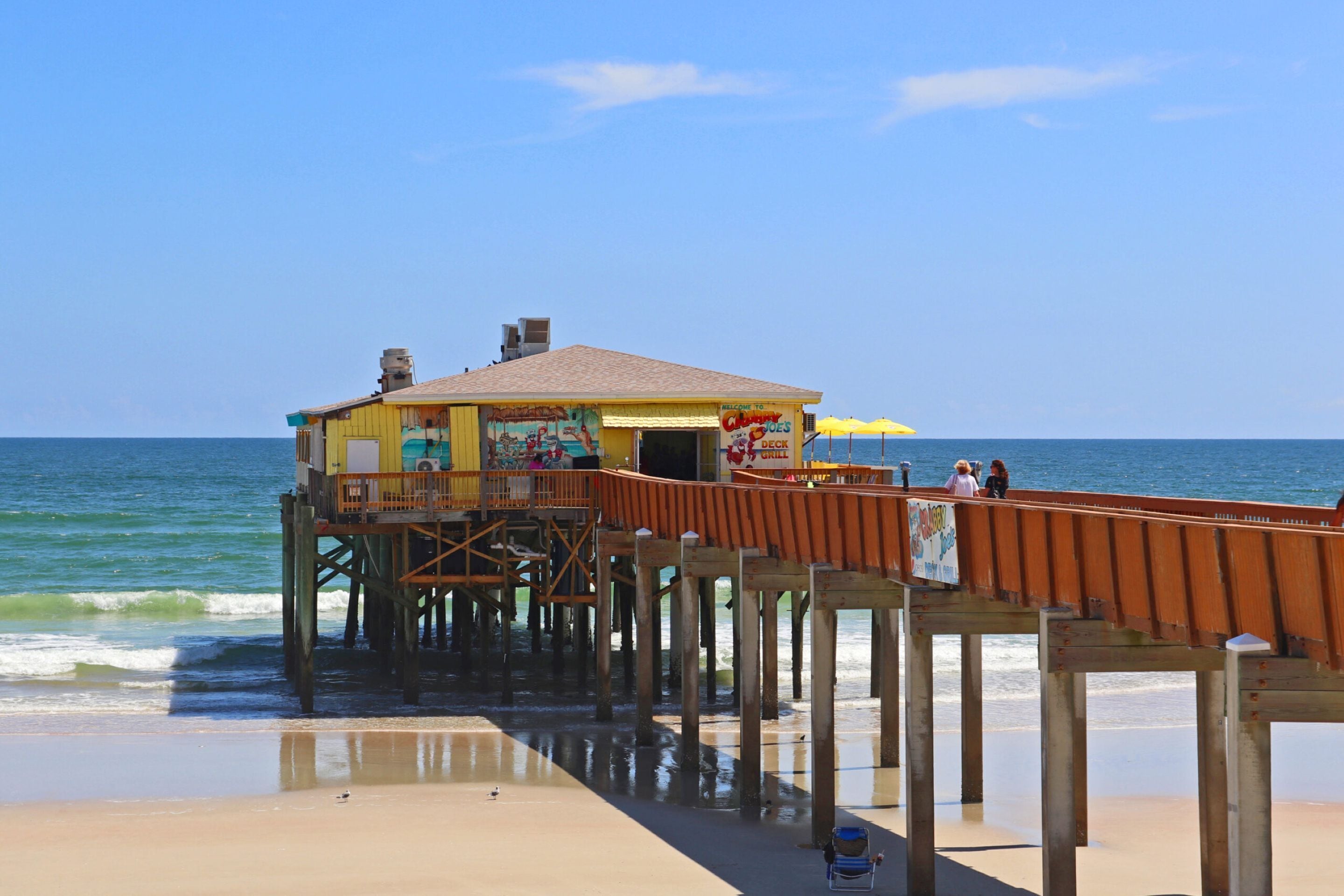 A pier with a restaurant at the end, overlooking the ocean.