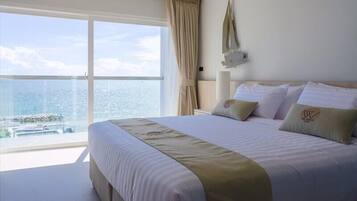 A hotel room with a large bed, a view of the city, and a balcony.