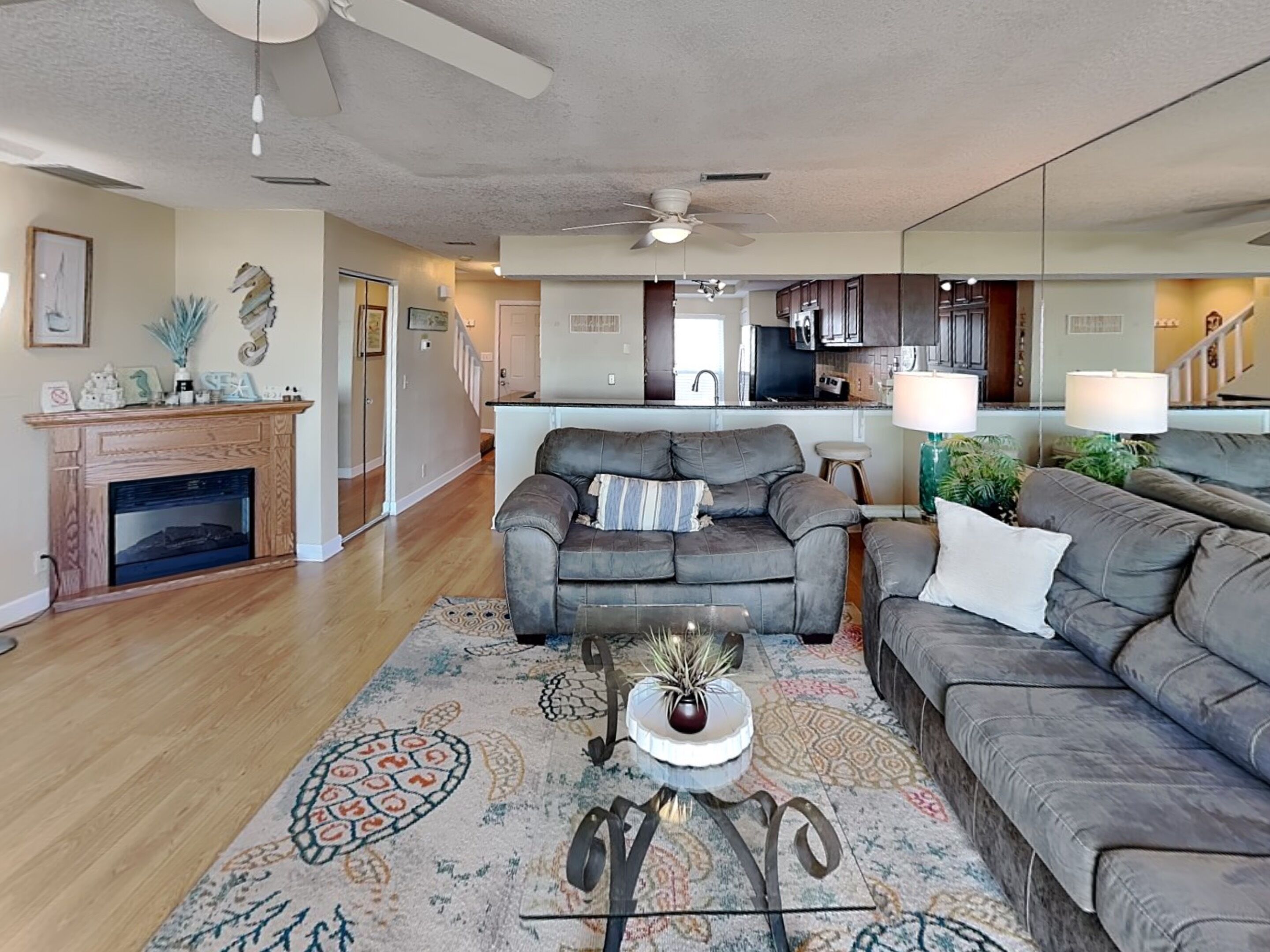 A living room with a fireplace, a sofa, a coffee table, and a rug.