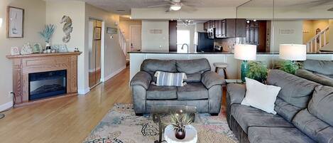 A living room with a fireplace, a sofa, a coffee table, and a rug.