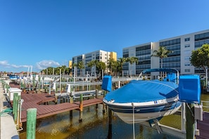 Boats docked at the marina, with a building in the background featuring large windows and a flat roof.