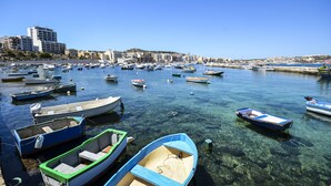 A marina with numerous boats docked, clear water, and buildings in the background. - Getawaysmalta - Seashells Apartment 11 With Terrace and Sea Views in Bugibba (St. Paul's Bay)