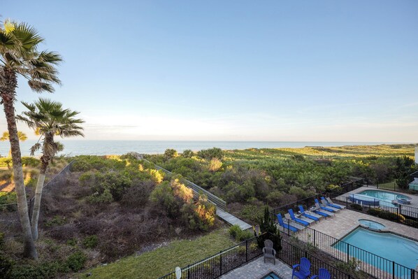 A pool area with lounge chairs, a small pool, and a view of the ocean. - Cinnamon Beach Nautilus by Distinctive Beach Rentals (Palm Coast)