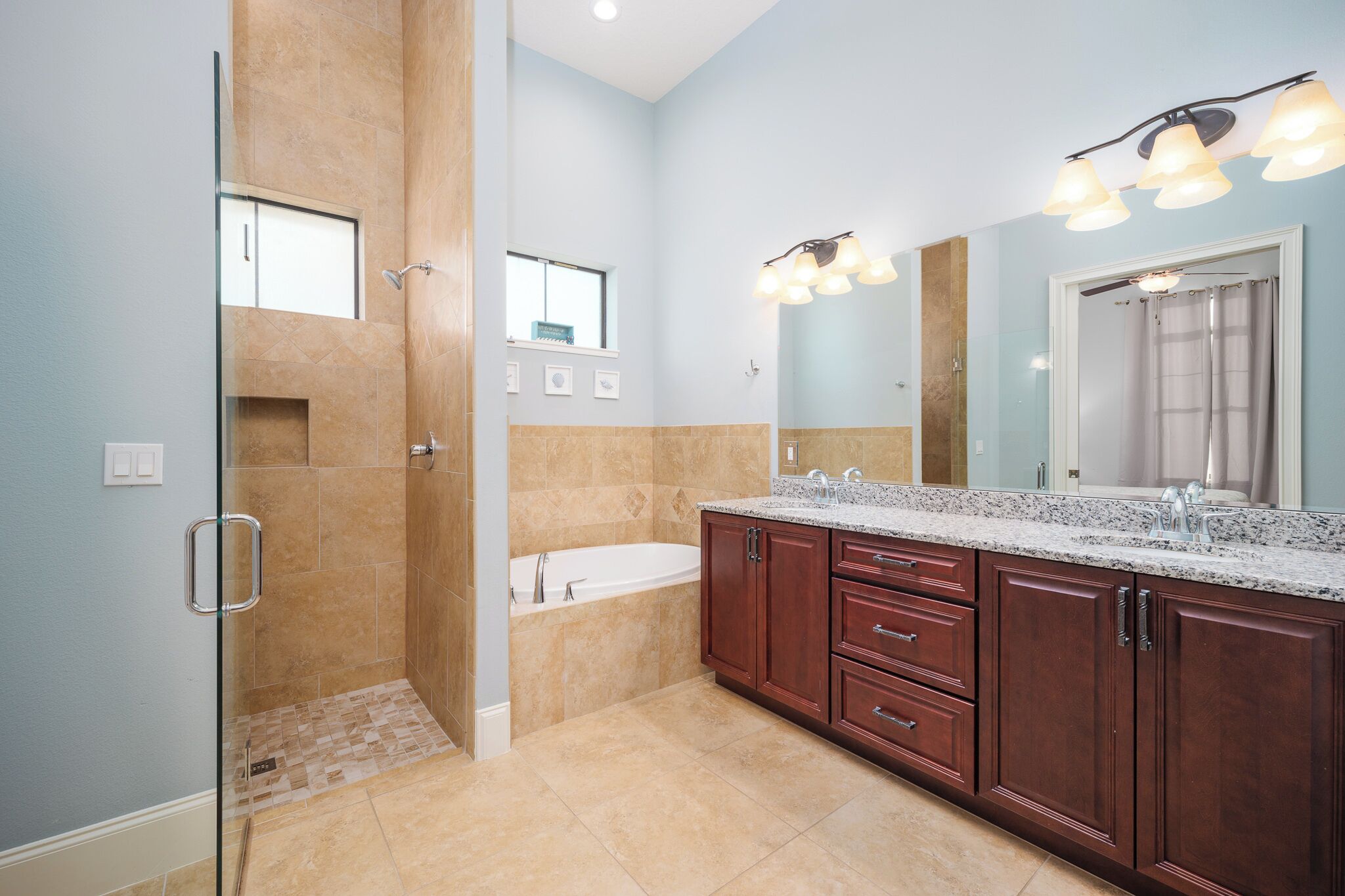 A modern bathroom with a walk-in shower, a bathtub, and a vanity with a large mirror.