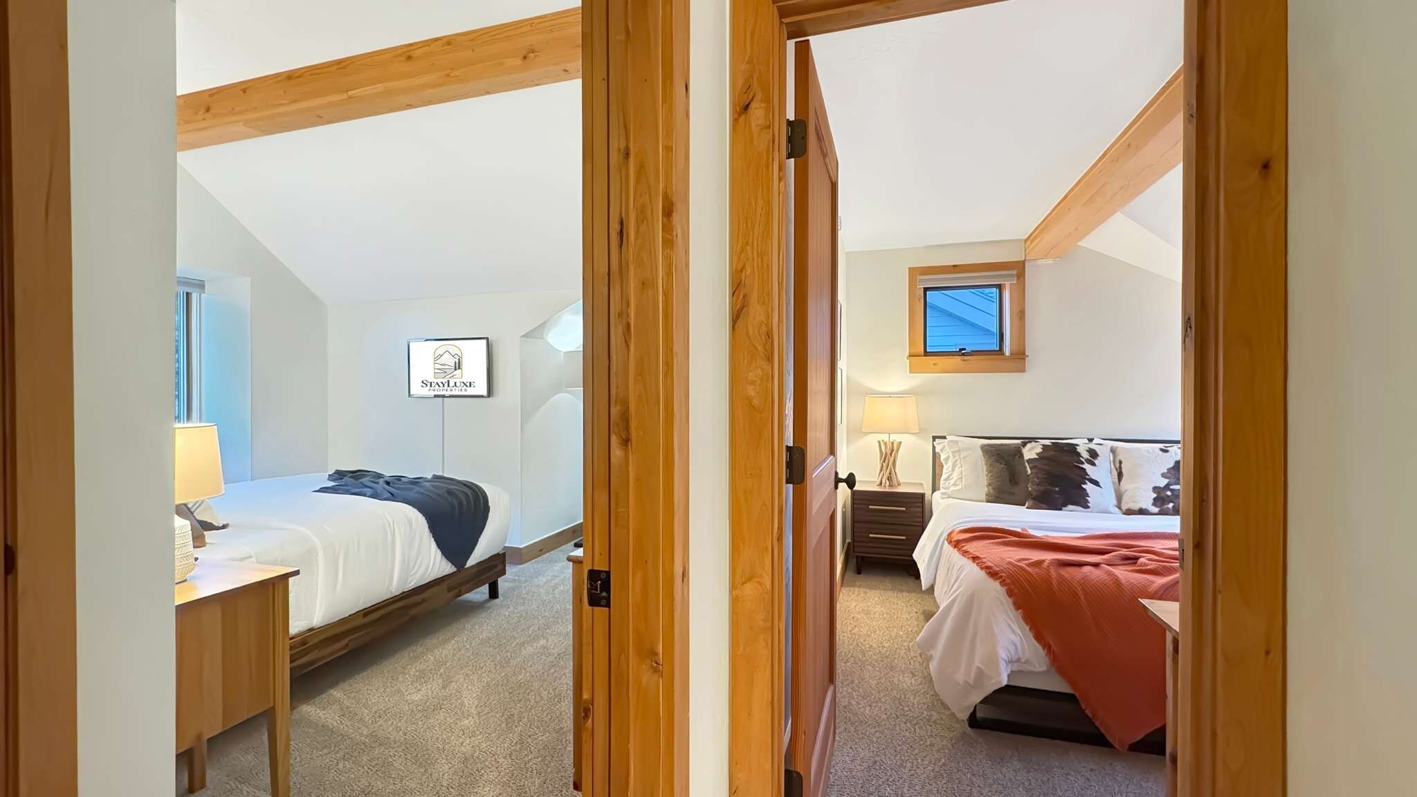 A bedroom with a bed, bedside table, lamp, and a window.