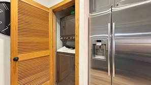 Una cocina con refrigerador de acero inoxidable, horno empotrado y dispensador de agua.