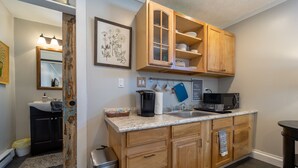 A kitchen with wooden cabinets, a granite countertop, a sink, a coffee maker, and a microwave. - Lovely, clean and walkable in the town of Luray.  (Luray)