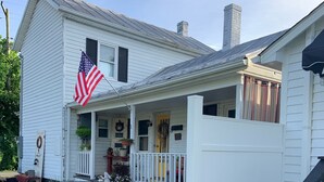 A white two-story house with a porch, a flag, and a chimney. - Lovely, clean and walkable in the town of Luray.  (Luray)