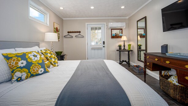 A bedroom with a bed, bedside tables, a dresser, a mirror, and a television. - Lovely, clean and walkable in the town of Luray.  (Luray)