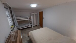 A small, compact room with a bunk bed, a wardrobe, and a bedside table. - Welcome to the North Sea! 🏖️ (Cuxhaven)