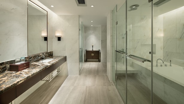 A modern bathroom with a marble countertop, a large mirror, a glass shower enclosure, and a wooden vanity. - Crowne Plaza Yading by IHG (Garze)