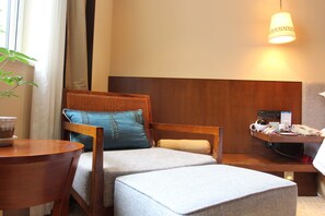 A hotel room with a bed, a desk, a chair, a small table, and a lamp. - Crowne Plaza Yading by IHG (Garze)