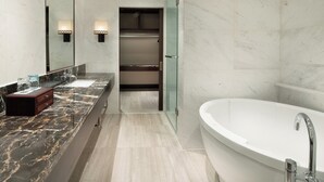 A modern bathroom with a marble vanity, a freestanding bathtub, and a walk-in closet. - Crowne Plaza Yading by IHG (Garze)