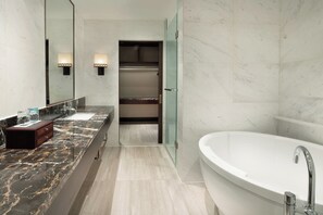 A modern bathroom with a marble vanity, a freestanding bathtub, and a walk-in closet. - Crowne Plaza Yading by IHG (Garze)