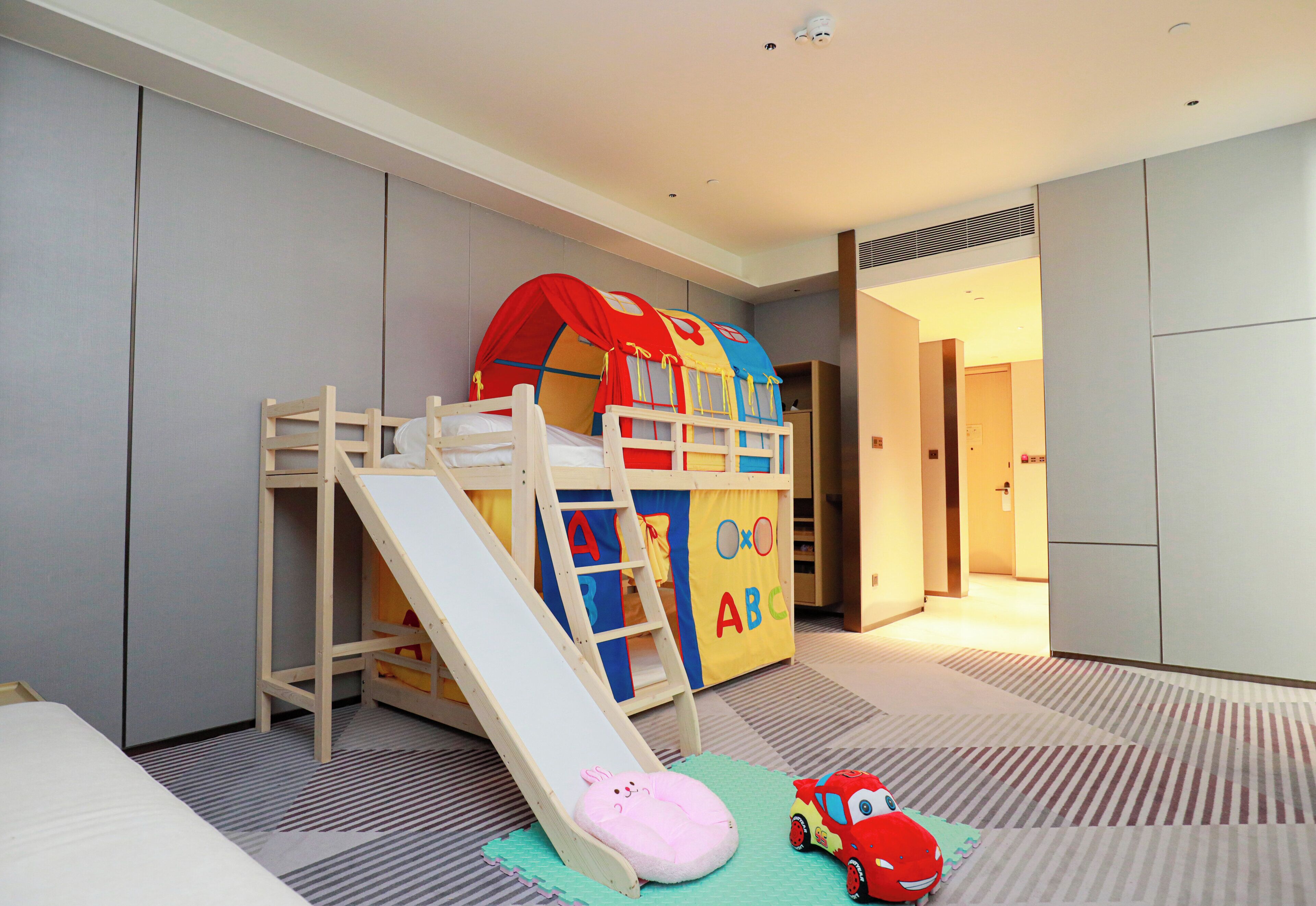 A children's play area with a slide, a playhouse, and a toy car.