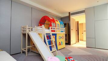 A children's play area with a slide, a playhouse, and a toy car.