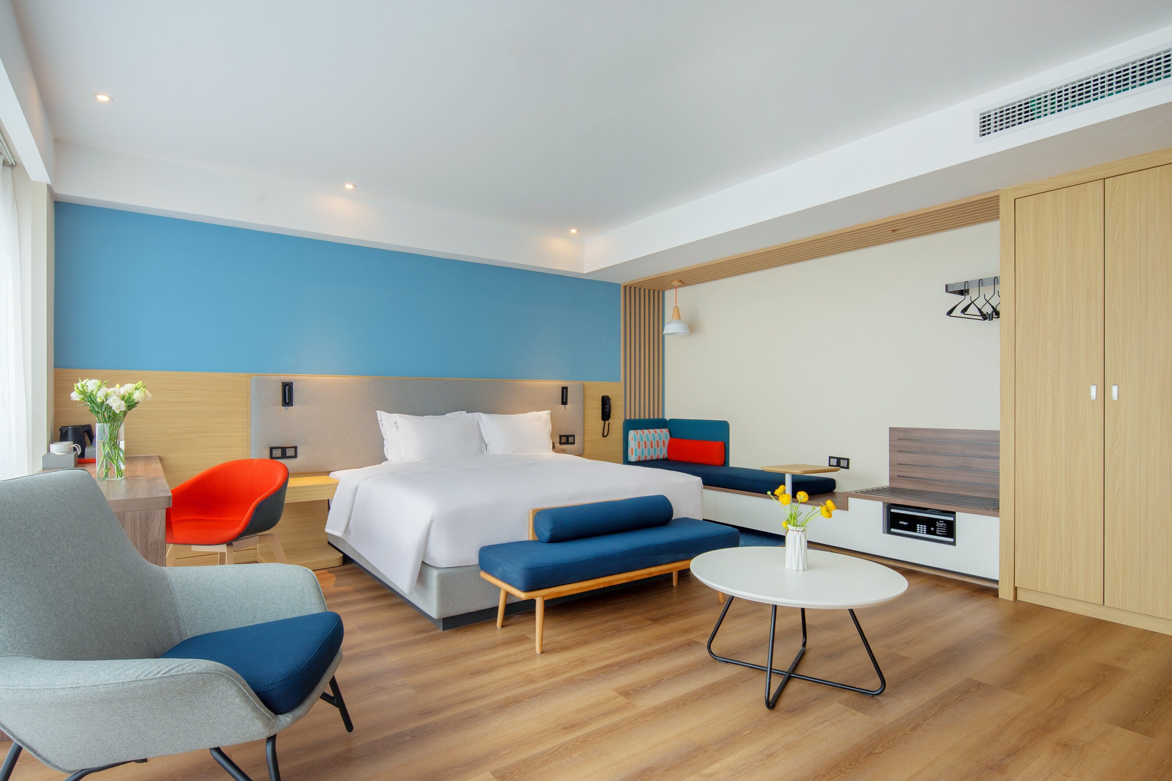 Une chambre d’hôtel moderne équipée d’un grand lit, d’un canapé, d’une table à manger et d’une kitchenette.