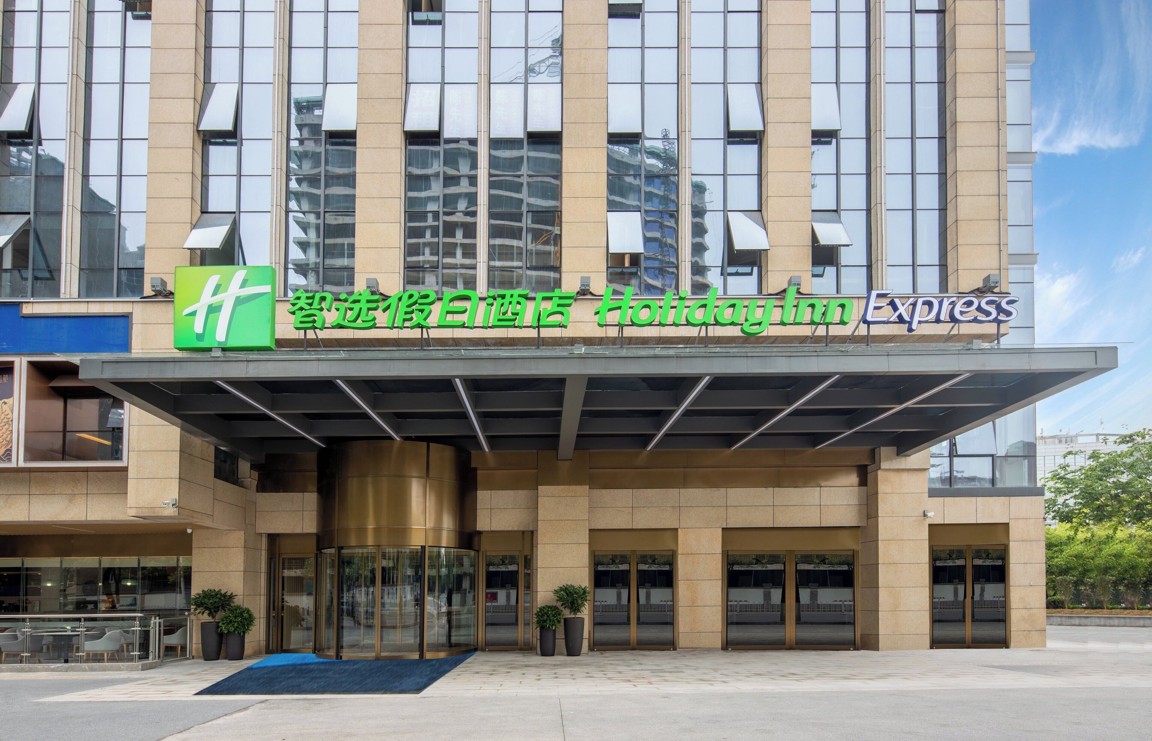 A hotel with a modern facade, large glass windows, and signage for Holiday Inn Express.