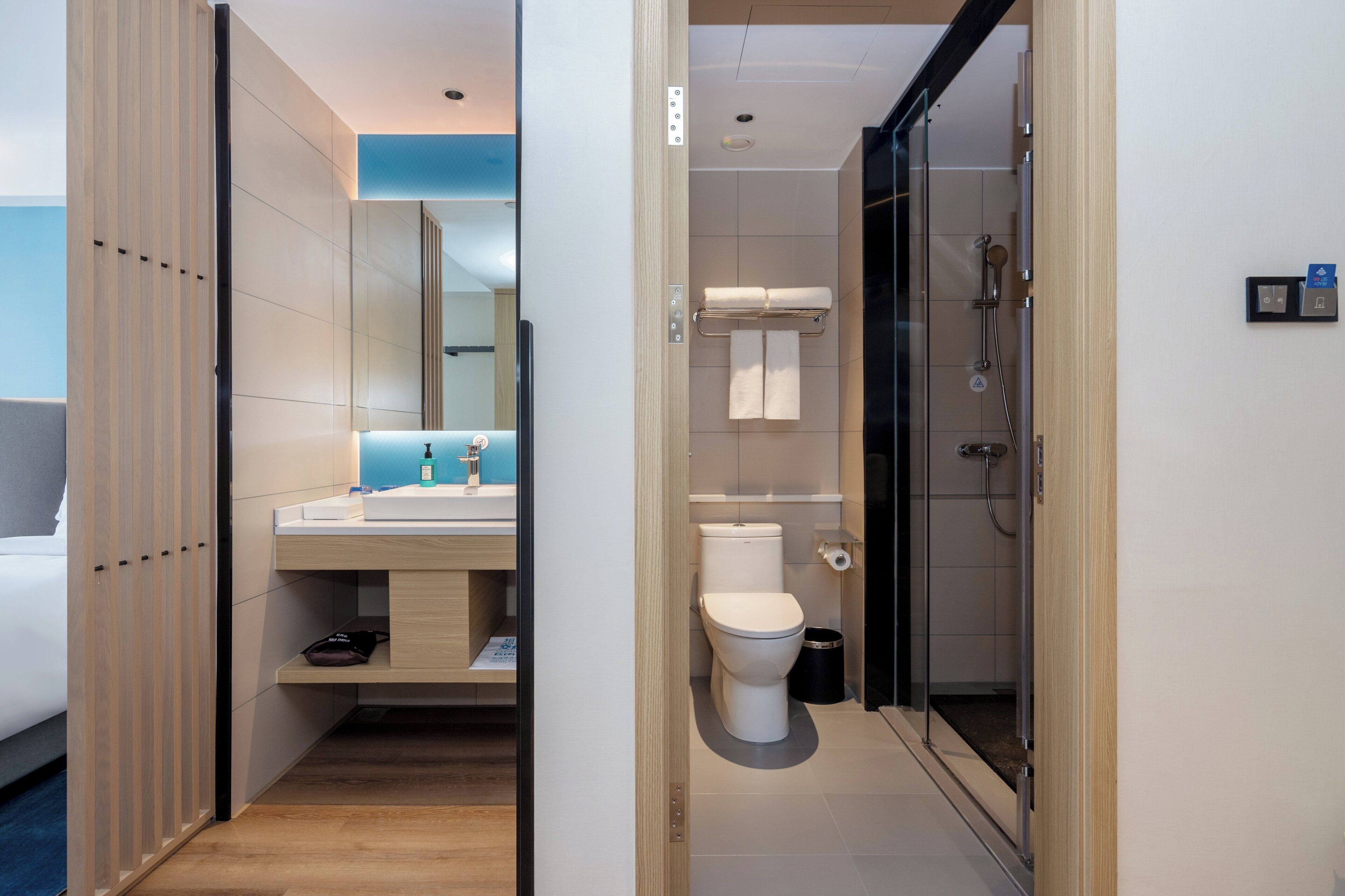 A modern bathroom with a shower, toilet, and sink.