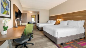 A hotel room with a desk, two beds, a TV, and a potted plant. - Holiday Inn Express & Suites Wildwood The Villages by IHG (Wildwood)