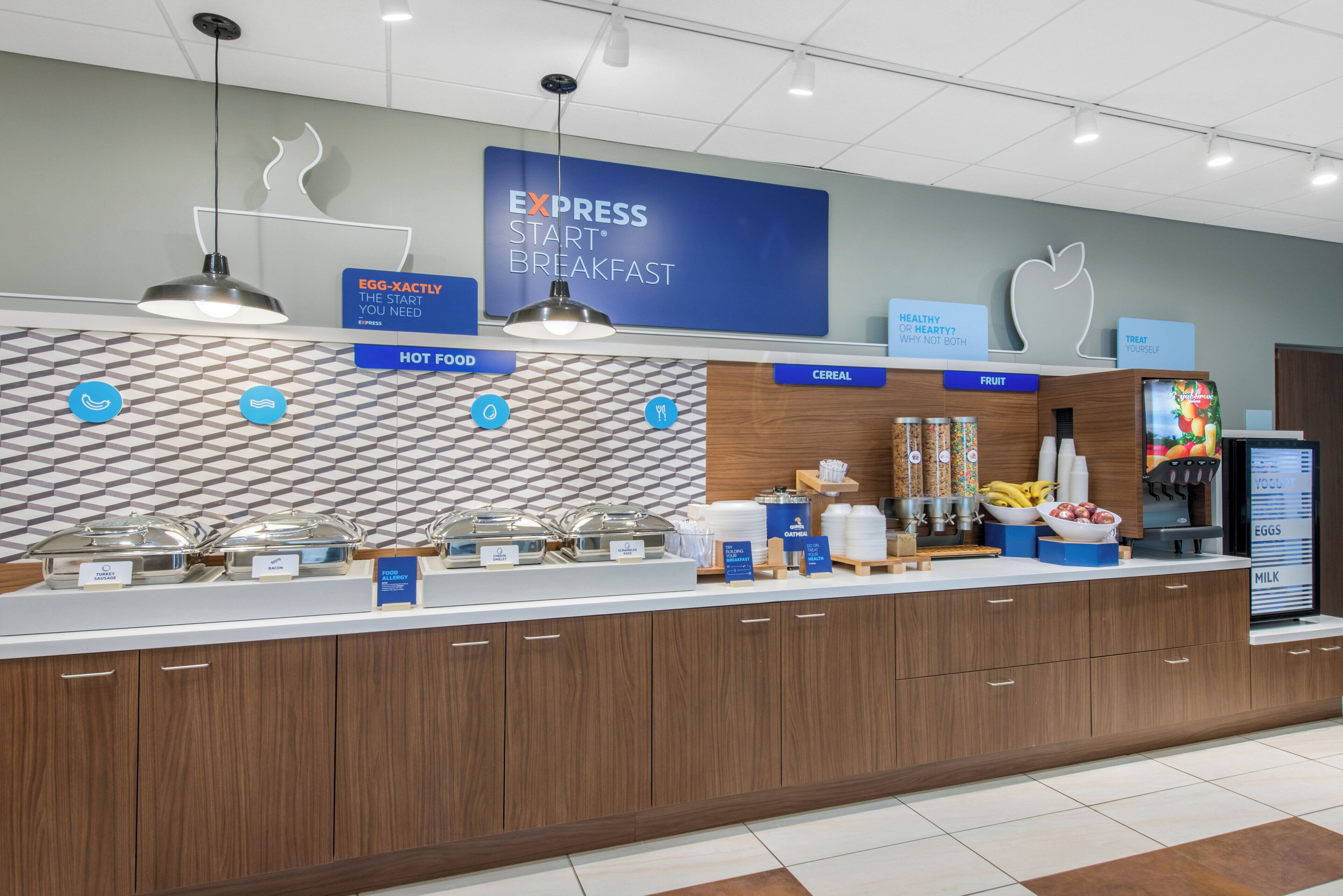 A breakfast buffet area with labeled sections for hot food, cereal, fruit, and eggs.
