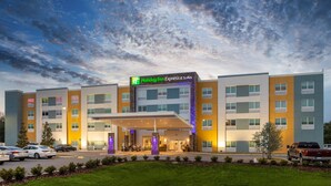 A Holiday Inn Express & Suites hotel with a modern design, featuring a covered entrance and multiple floors.