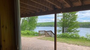 Una terraza de madera con vistas a un lago y un bosque.
